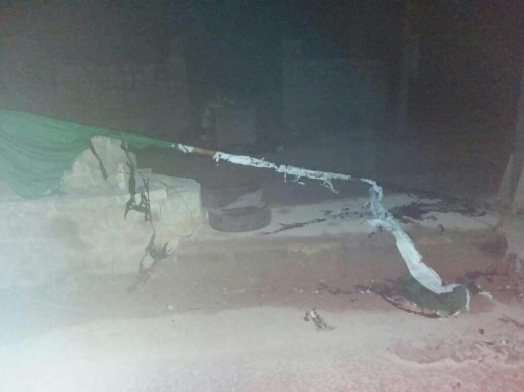 صورةً تثبت قيام عناصر من هيئة تحرير الشام بحرق علم الثورة السورية