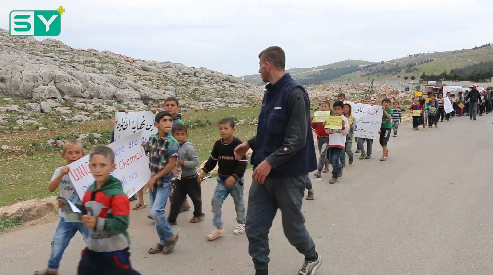 عشرات الأطفال يتظاهرون بالقرب من معبر باب الهوى نصرةً لمدينة دوما