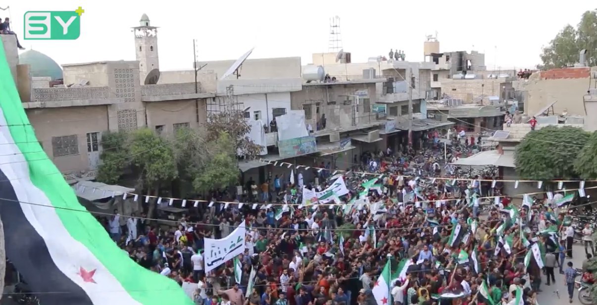 علم الثورة يغطي الساحة الرئيسية في مدينة كفرنبل في مظاهرة “الأسد مصدر الإرهاب”