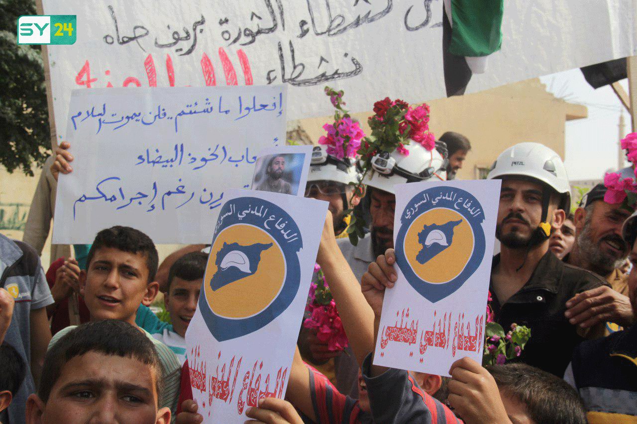 متظاهرو بلدة كفرنبودة بريف حماة يستقبلون الدفاع المدني بالورود