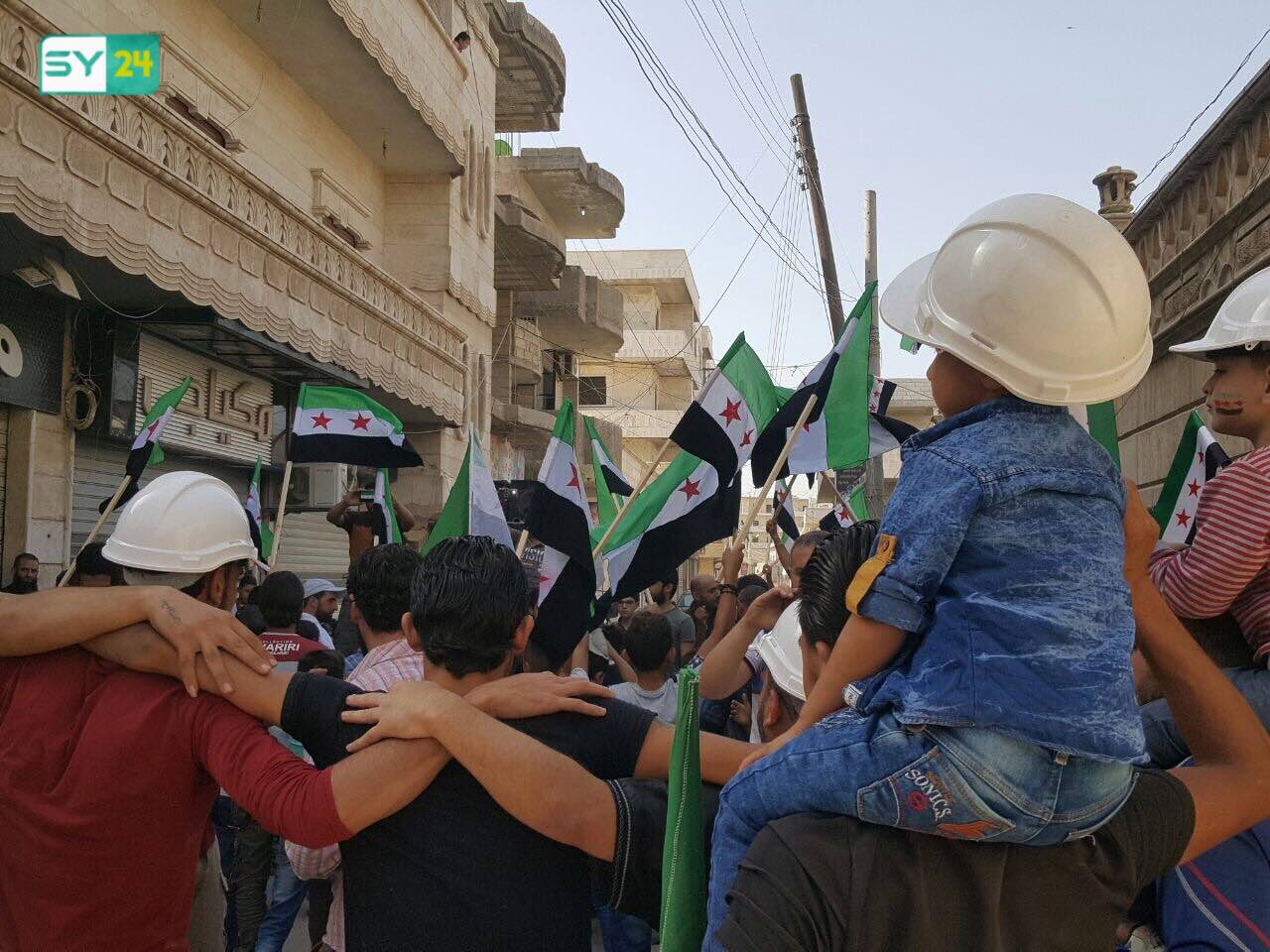 متظاهرون في سرمدا يرتدون الخوذ البيضاء تضامناً مع الدفاع المدني