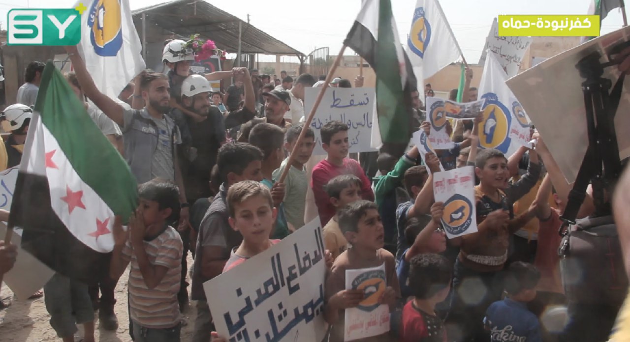 متظاهرو بلدة كفرنبودة بريف حماة يستقبلون الدفاع المدني بالورود