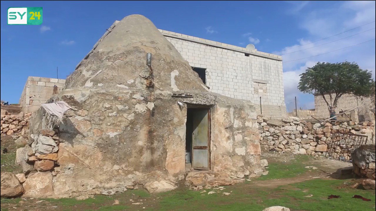 مسنة تعيش داخل كهف طيني منذ 20 عاماً في إدلب.. ما قصتها؟